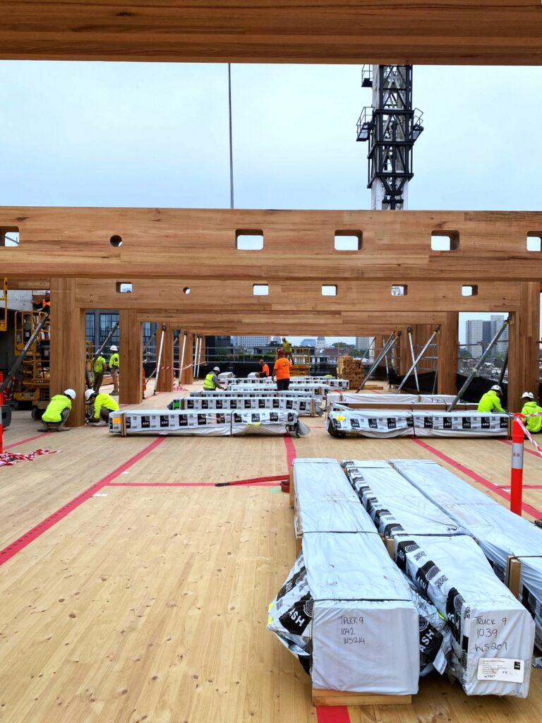 T3 Collingwood during construction featuring MASSLAM columns and beams. Image: ASH T3 Collingwood during construction lifting MASSLAM (mass timber) beams into place. Image credit: ASH